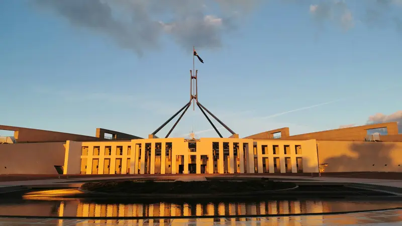 Parliament House in Canberra at sunset, reflected in the forecourt pool